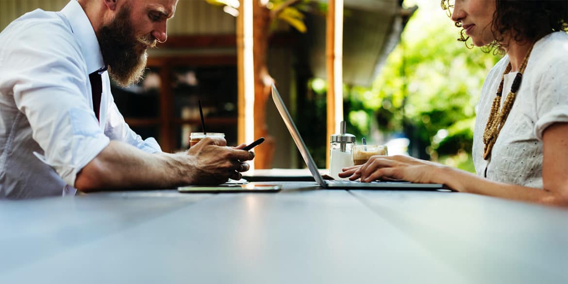 Employees on table with laptop and phone